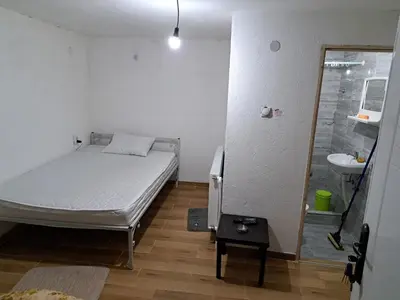 a small bedroom with a bed and a sink at Hostel Lalinac in Niš