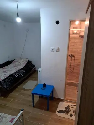 a small room with a bed and a blue table at Hostel Lalinac in Lalince