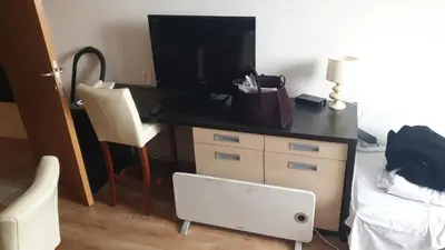 a bedroom with a desk with a television and a chair at Zoned spa aparman in Kopaonik