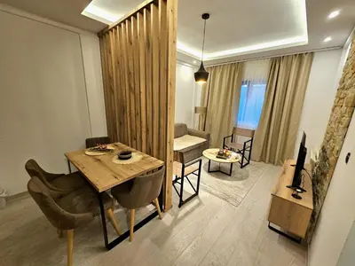 a living room with a table and a living room with a couch at Apartman AniLu Milmari Resort N40 in Kopaonik