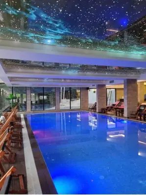 a swimming pool in a house with a star ceiling at Apartman AniLu Milmari Resort N40 in Kopaonik