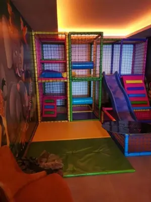 a childrens play room with a slide and play equipment at Apartman AniLu Milmari Resort N40 in Kopaonik