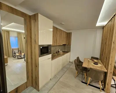 a kitchen with a table and a dining room at Apartman AniLu Milmari Resort N40 in Kopaonik
