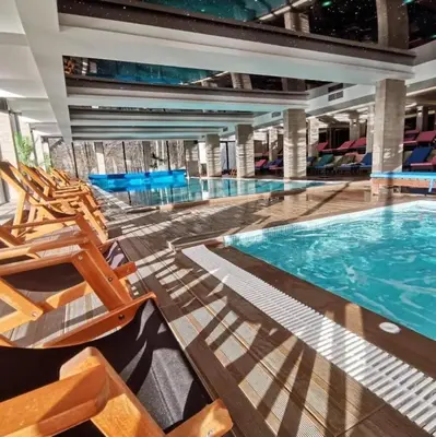 a large swimming pool with chairs and a swimming pool at Apartman AniLu Milmari Resort N40 in Kopaonik