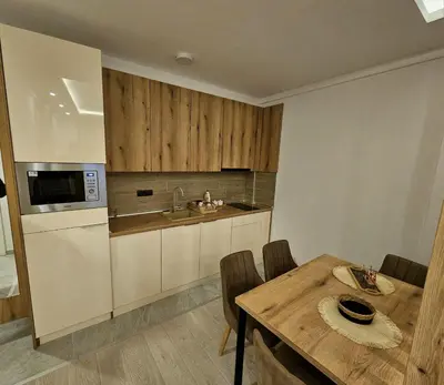 a kitchen with a table and a sink and a microwave at Apartman AniLu Milmari Resort N40 in Kopaonik