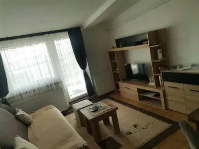 a living room with a couch and a tv and a table at Mala Sirena in Pirot