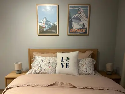 a bed with two framed posters on the wall at Apartman Nikolic 417 in Kopaonik