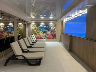 a row of chairs in a waiting room with an aquarium at Apartman Nikolic 417 in Kopaonik