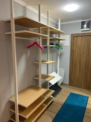 a room with wooden shelves and a blue rug at Apartman Nikolic 417 in Kopaonik