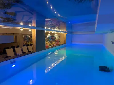 a swimming pool in a building with blue lighting at Apartman Nikolic 417 in Kopaonik