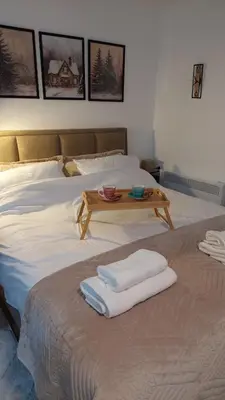 a bed with two towels and a table on it at Kopaonik Alibi25 in Kopaonik