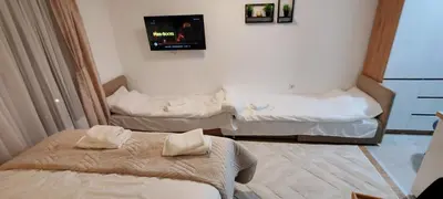 a room with two beds and a tv on the wall at Kopaonik Alibi25 in Kopaonik