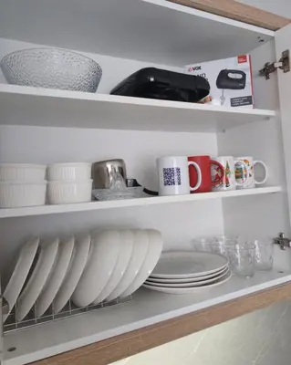 a kitchen shelf with plates and cups and dishes at Kopaonik Alibi25 in Kopaonik