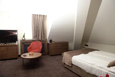 a bedroom with a bed and a table and a tv at Deluxe Studio 19, Kula, Konaci, Kopaonik