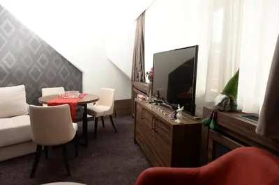 a living room with a tv and a table with chairs at Deluxe Studio 19, Kula, Konaci, Kopaonik