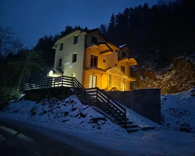a house sitting on top of a hill in the snow at Suncani breg in Crni Vrh