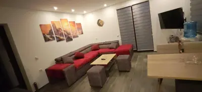 a living room with a red couch and a table at Suncani breg in Crni Vrh
