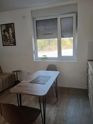 a kitchen with a table and two windows in a room at Studio Carina in Soko Banja