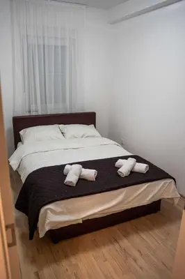 a bedroom with a bed with two towels on it at Apartman Nana in Vranje