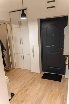 a room with a black door and white cabinets at Apartman Nana in Vranje