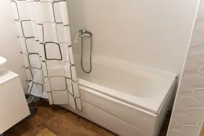 a white bath tub with a shower curtain in a bathroom at Apartman Nana in Vranje