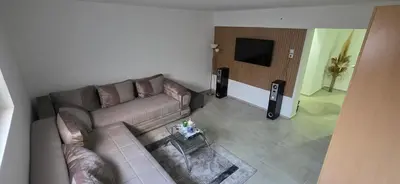 a living room with a couch and a television at Pansion Mima in Niš