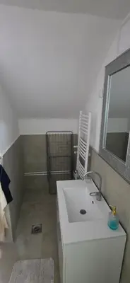 a bathroom with a white sink and a mirror at Pansion Mima in Niš