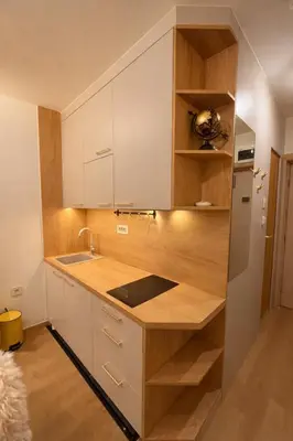 a kitchen with white cabinets and a wooden counter top at Konaci Prime Center in Kopaonik