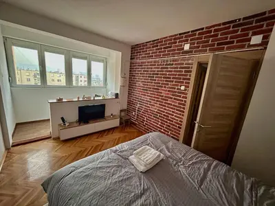 a bedroom with a brick wall and a bed at Tilia in Zaječar