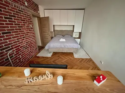 a small bedroom with a bed and a brick wall at Tilia in Zaječar