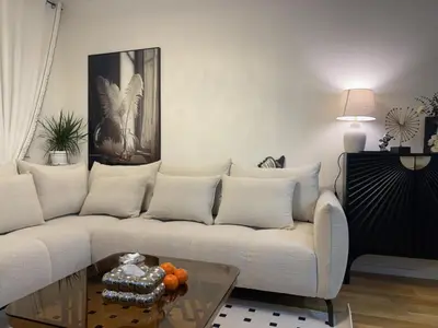 a living room with a white couch and a table at Stan na dan Bor Apartman in Bor