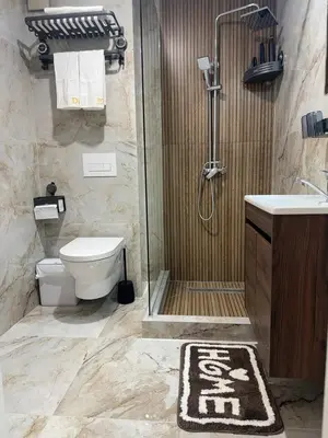 a bathroom with a shower and a toilet and a sink at Stan na dan Bor Apartman in Bor