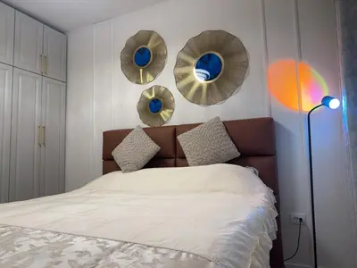 a bedroom with a bed and three mirrors on the wall at Stan na dan Bor Apartman in Bor