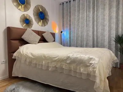 a bedroom with a bed with mirrors on the wall at Stan na dan Bor Apartman in Bor