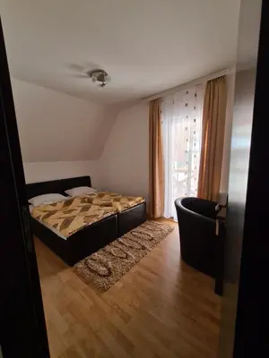 a bedroom with a bed and a couch and a window at VILA KRUNA Apartments in Kopaonik