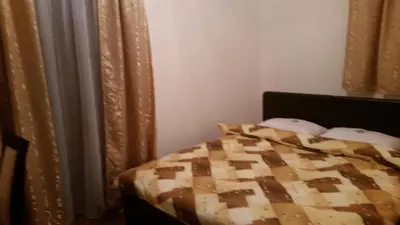a bedroom with a bed with a brown and white quilt at VILA KRUNA Apartments in Kopaonik
