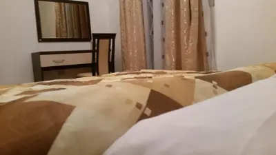 a bed with a brown and white blanket on it at VILA KRUNA Apartments in Kopaonik