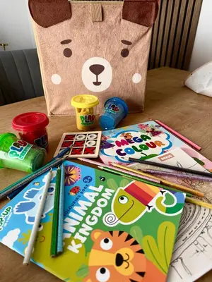 a table with childrens books and a paper bag at Apartman IRIS Kopaonik in Kopaonik