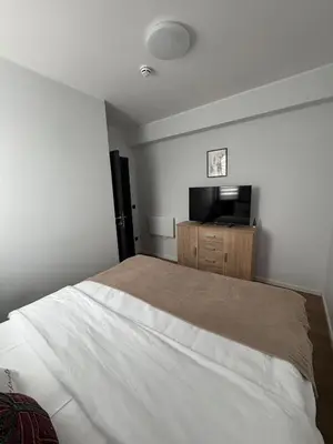 a bedroom with a large bed and a flat screen tv at Apartman IRIS Kopaonik in Kopaonik