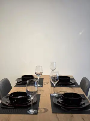 a table with plates and wine glasses on it at Apartman Raj VV sa garazom in Vrnjci