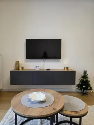 a living room with a table and a tv at Apartman Raj VV sa garazom in Vrnjci