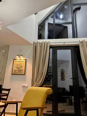 a yellow chair sitting next to a glass door at Ćilibar Stara planina in Crni Vrh