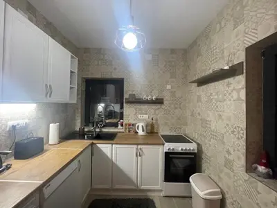 a small kitchen with white cabinets and a sink at Ćilibar Stara planina in Crni Vrh