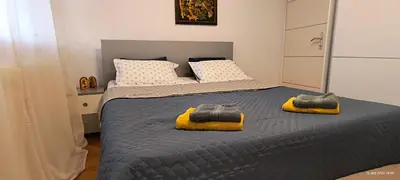 a bedroom with two beds with towels on the bed at Apartman Vidačić in Pirot