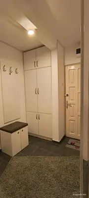 an empty room with white cabinets and a door at Apartman Vidačić in Pirot
