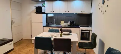 a kitchen with a table and chairs in a kitchen at Apartman Vidačić in Pirot