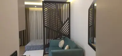 a living room with a blue couch and a bed at Apartman MM84b Residence Hill in Lisina