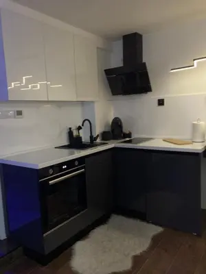 a kitchen with white cabinets and a black stove top oven at Star&spa in Niš