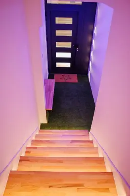 a stairway with a blue door and a staircase with wooden floors at Star&spa in Niš