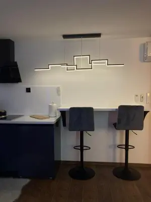 a kitchen with two bar stools and a light at Star&spa in Niš